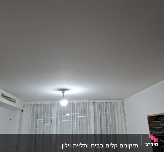 תאורה ותקרה בחדר מגורים עם וילונות לבנים